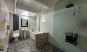 a bathroom with a tub and a toilet and a sink at Sasang Goyohan-hotel in Busan