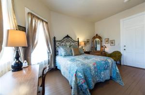 A bed or beds in a room at Grand Victorian Inn