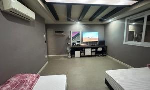 a room with a bedroom with a desk and a tv at Sasang Goyohan-hotel in Busan