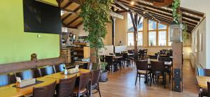 a restaurant with tables and chairs in a room at Feriendorf Hochbergle Haus 34 in Lechbruck
