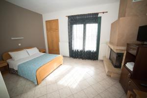 Un dormitorio con una cama y una ventana en Hotel Galaxias, en Kato Loutraki