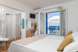 a bedroom with a bed with a view of the ocean at Apanemo Seaside in Batsi