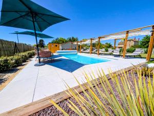 a swimming pool with a bench and an umbrella at Gite Les Intemporels in Cuisery