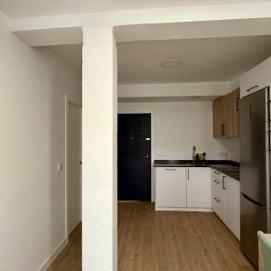 a kitchen with white cabinets and a black refrigerator at Azahar Home Sevilla in Seville