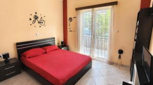 a bedroom with a red bed and a large window at Vens apartment 90m2 at Eantio bay. in Aiándion