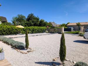 a garden with two trees and an umbrella at Gite Les Intemporels in Cuisery