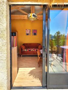 a living room with a couch and a glass door at le clos d'Yrem in La Rochegiron