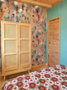 a bedroom with a bed and a floral wallpaper at le clos d'Yrem in La Rochegiron +7 photos