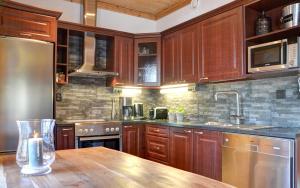 a kitchen with wooden cabinets and a wooden table at PUTTITIE 4A in Tahkovuori