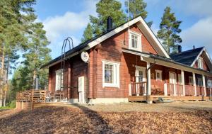a large wooden house with a porch at PUTTITIE 4A in Tahkovuori