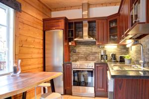 a kitchen with wooden cabinets and a stainless steel refrigerator at PUTTITIE 4A in Tahkovuori