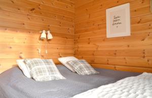 a bedroom with a bed in a wooden wall at PUTTITIE 4A in Tahkovuori