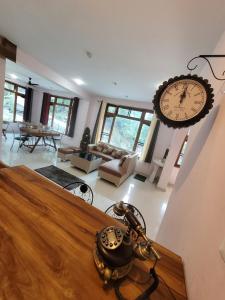 a living room with a large clock hanging on the wall at Vikas Hotel And Restaurant in Barot 