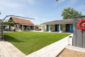 a house with a yard with a green lawn at Nautical Toroni Rooms in Toroni