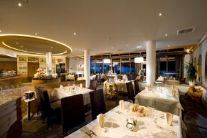 a restaurant with white tables and chairs and a dining room at Hotel Sonnalp 4 Sterne Superior in Obereggen