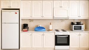 a kitchen with white cabinets and a white stove top oven at Vens apartment 90m2 at Eantio bay. in Aiándion +21 photos