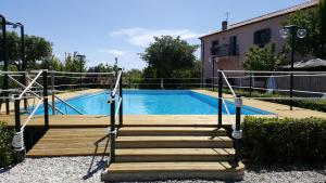 uma escada de madeira que leva a uma piscina em Residenza Solferino Castiglioncello em Castiglioncello