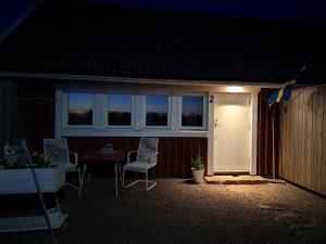 a house with a table and chairs and a door at Kinnekulle bed & breakfast in Källby