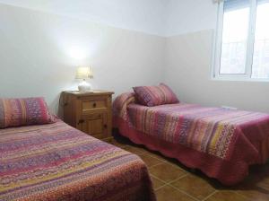 a room with two beds and a lamp and a window at Casa Galisa in Torrevieja