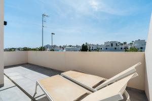 two chairs on a balcony with a view of a city at Bungalow Fausto Sunrise in Orihuela Costa