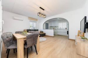a living room with a dining room table and a kitchen at Chalet Queen Venecia Sunrise in Campoamor