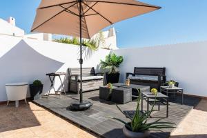 a patio with an umbrella and chairs and tables at Chalet Queen Venecia Sunrise in Campoamor
