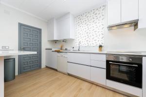 a kitchen with white cabinets and a black oven at Chalet Queen Venecia Sunrise in Campoamor