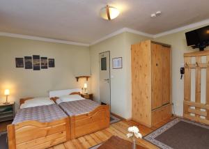 a bedroom with a large wooden bed and a television at Pensjonat Tara in Jeleśnia