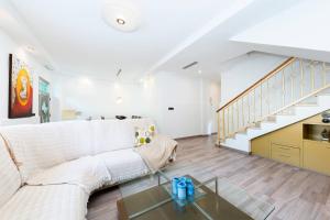 a living room with a white couch and a staircase at Maravillas in La Mata