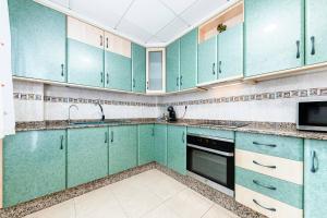 a kitchen with green cabinets and a microwave at Maravillas in La Mata