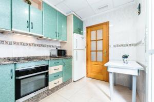 a kitchen with green cabinets and a white refrigerator at Maravillas in La Mata