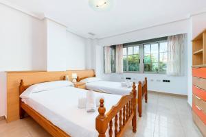 two beds in a room with two windows at Maravillas in La Mata