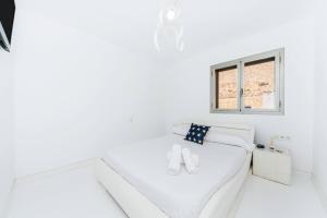 a white room with a bed and a window at Tabarca’s View Santa Pola in Santa Pola