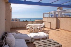 a balcony with a table and chairs and the ocean at Aguamarina Ático Duplex Gran Terraza Cabo Roig in Orihuela