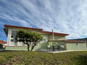 a table and chairs in front of a house at Casa Frutales - Landhaus mit Garten nahe Strand und Finisterre in Fisterra +10 photos