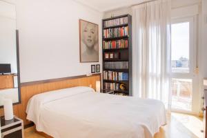 a bedroom with a bed and a book shelf with books at Aguamarina Ático Duplex Gran Terraza Cabo Roig in Orihuela