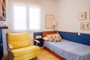 a bedroom with a yellow chair and a bed at Aguamarina Ático Duplex Gran Terraza Cabo Roig in Orihuela +12 photos
