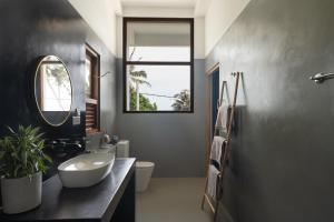 a bathroom with a sink and a toilet and a window at Chez Colette in Matara +24 photos