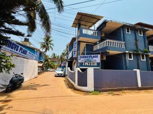 a motorcycle parked in front of a blue house at FabHotel Elvin's Place in Calangute