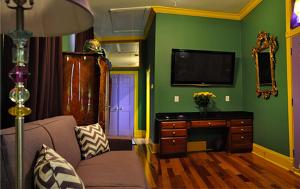 a living room with a couch and a flat screen tv at R&B Award Winning B&B - Adult Only in New Orleans