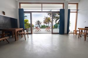 an open room with a table and chairs and a patio at Chez Colette in Matara