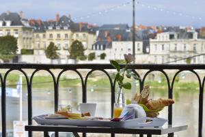 einen Tisch mit einem Teller Essen auf dem Balkon in der Unterkunft Cristal Hôtel Restaurant in Saumur