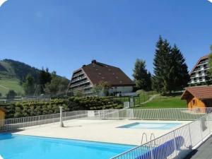 an empty swimming pool with a fence around it at Le Nid Cozy - Appart avec Piscine, Terrain de Tenis et Balcon in Métabief