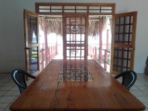 einen Holztisch mit Stühlen in einem Zimmer in der Unterkunft Villa Tortugas in Monterrico