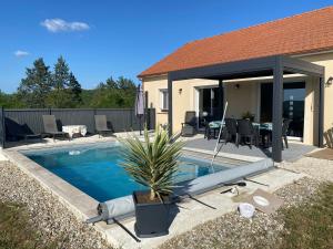 a swimming pool in front of a house at Vacances Vallée de la Dordogne in Souillac