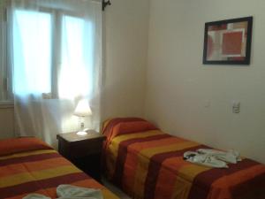 a hotel room with two beds and a window at Hotel Wilton in Mar del Plata