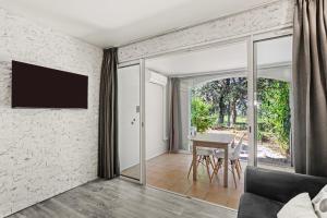 a living room with a table and sliding glass doors at Apartment – Restanques – Swimming in Grimaud