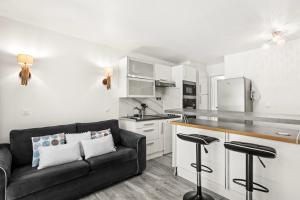 a living room with a couch and a kitchen at Apartment – Restanques – Swimming in Grimaud