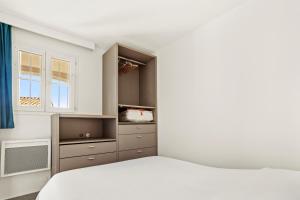 a white bedroom with a bed and a window at Apartment – Restanques – Swimming in Grimaud +20 photos