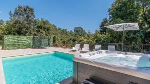 a hot tub in a backyard with chairs and an umbrella at Villa Zebo by Villas Guide in Barban